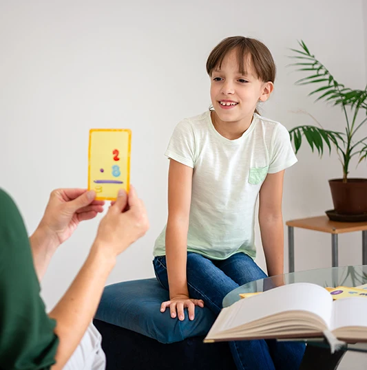mädchen schaut lächelnd auf Diagnostikkarte