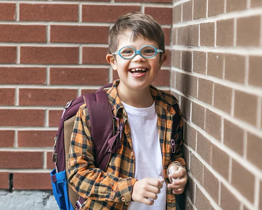ein lächelnder Junge mit blauer Brille